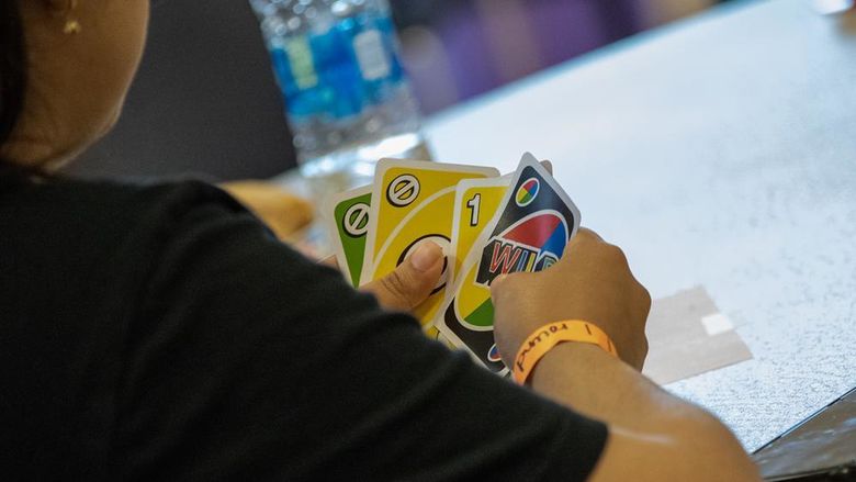 Closeup photo of hands holding Uno cards