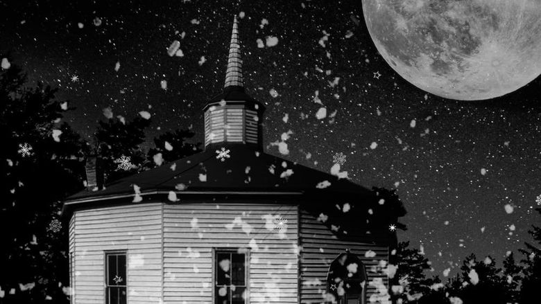 black and white image of a church on a snowy moonlit night