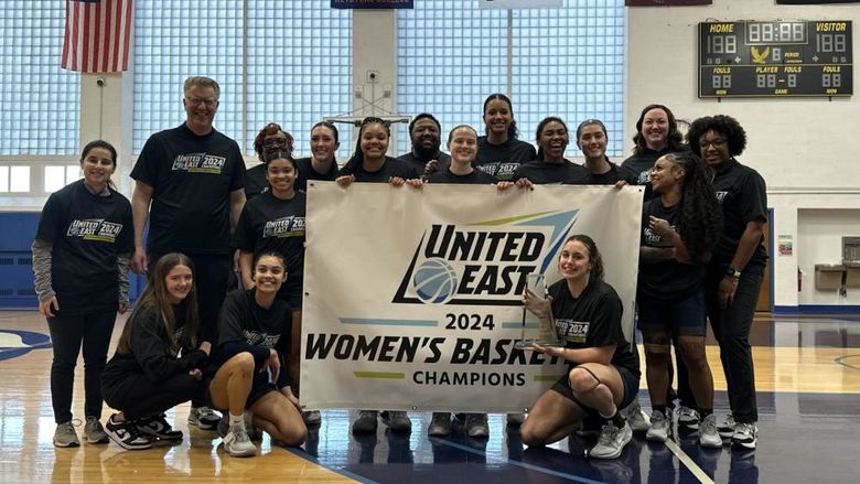 Penn State Harrisburg women's basketball team holding a banner that says United East 2024 Women's Basketball Champions