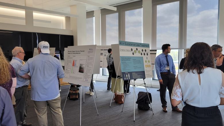 People standing in a room looking at conference posters