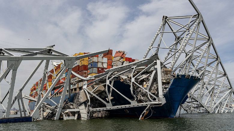 Cargo ship under bridge wreckage