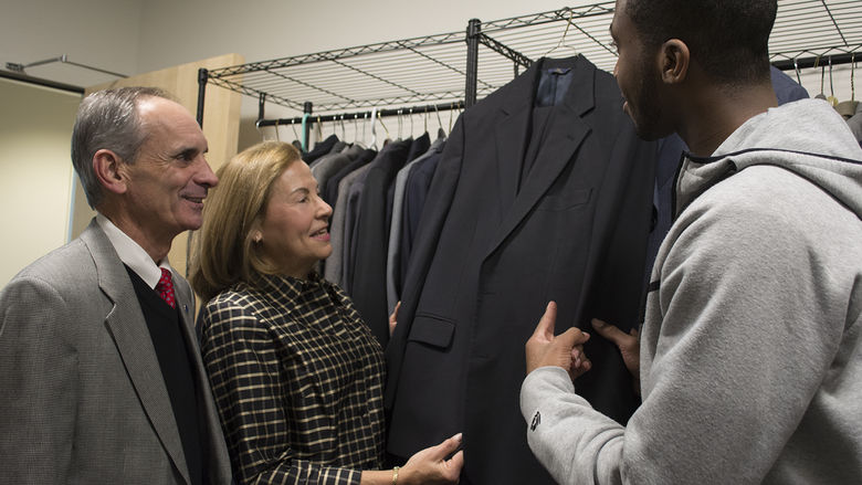 Chancellor Mason and Wife with Student looking at suit