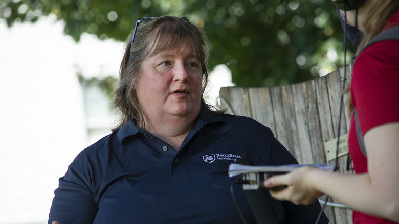 Shirley Clark, wearing a Penn State Harrisburg shirt, speaks with a reporter outdoors