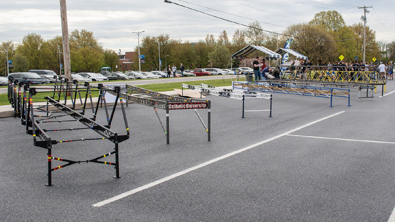 Steel bridges lined up in a  Penn State Harrisburg parking lot for a competition