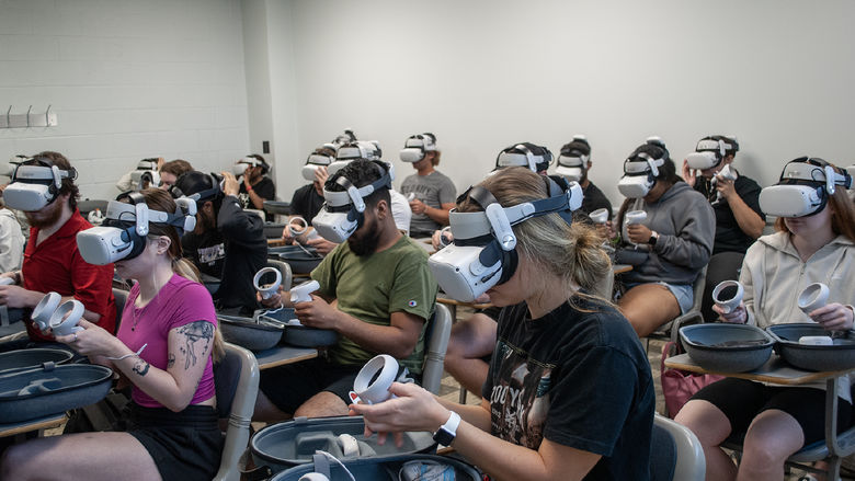 A classroom full of students wearing virtual reality headsets and holding the controllers
