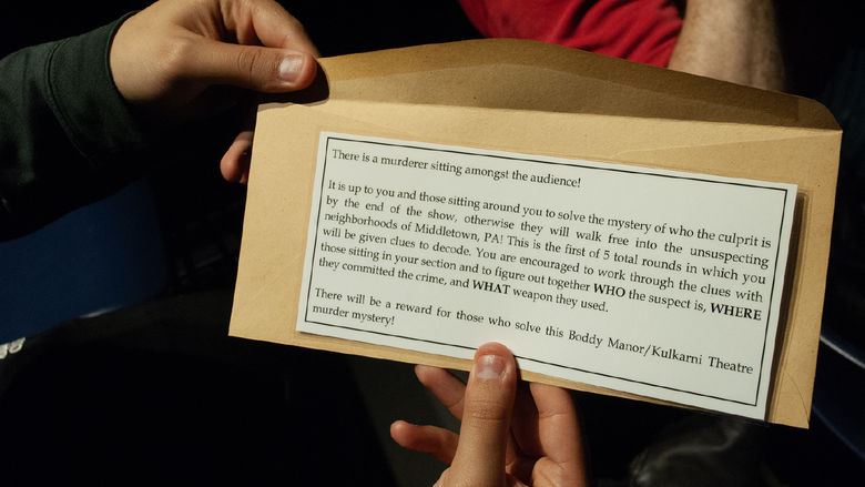 Closeup of an envelope with instructions for solving a mystery during a performance of "Clue"