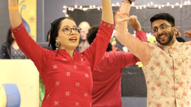 Two students dance at a Holi celebration