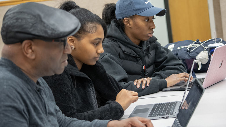 Greg Jenkins, professor of meteorology and atmospheric science at Penn State, high school student Ariam Gebrezgi, and Penn State Harrisburg student Makaylin Valley go over research on their laptops