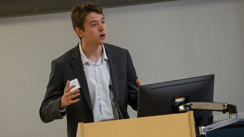 Aiden Beiler stands at a lectern while making a business pitch