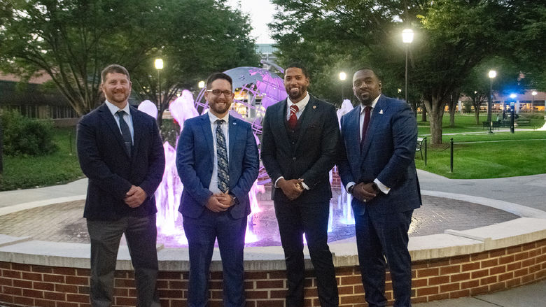 Four recipients of the People to Watch Award gather by the fountain at Penn State Harrisburg
