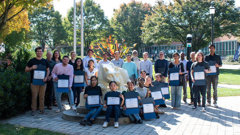 Group photo of REU award participants by the Nittany Lion statue