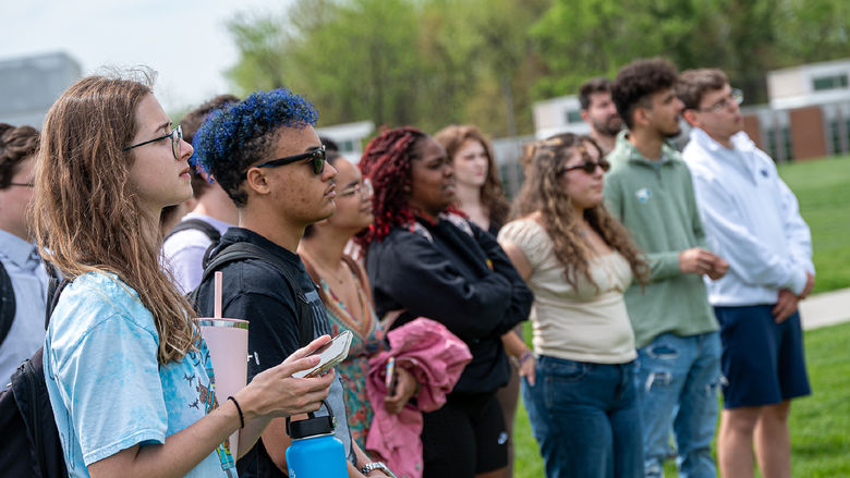A crowd of students watch a groundbreaking ceremony