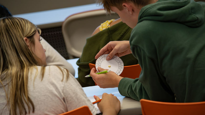 Students look at a cipher wheel during a STEM activity