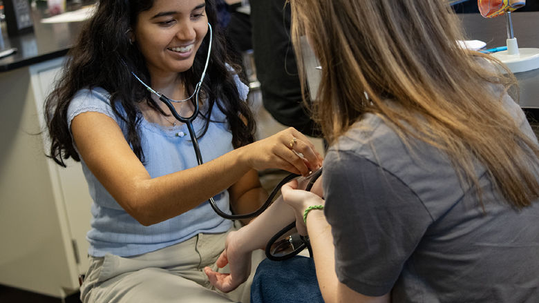 High School students listen with stethoscopes during an activity