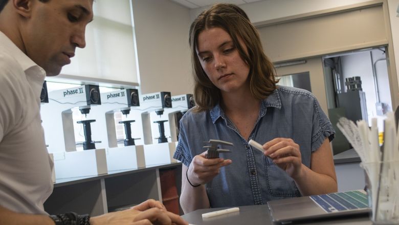 A man and a woman measuring samples in the lab