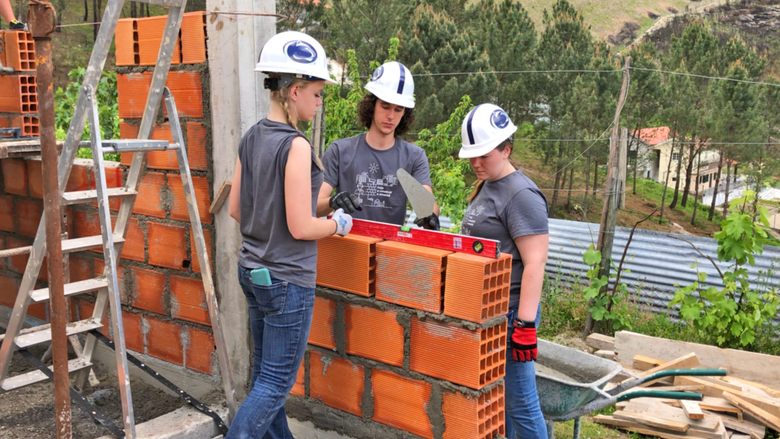 Penn State Schuylkill students Marla, Ian, and Alyssa build a wall in their Portugal Habitat for Humanity build site.