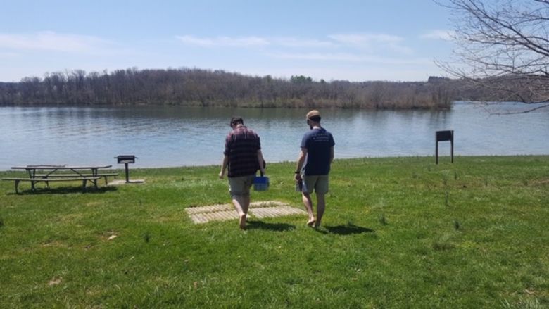 Two people facing out looking at a lake