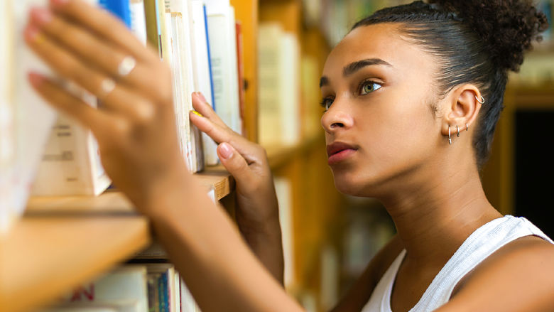 female looking at books on shelf