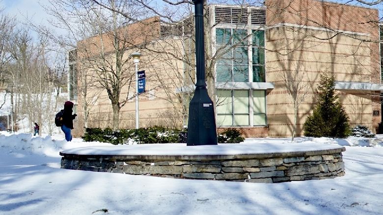 A clock tower on a sunny day with snow on the ground