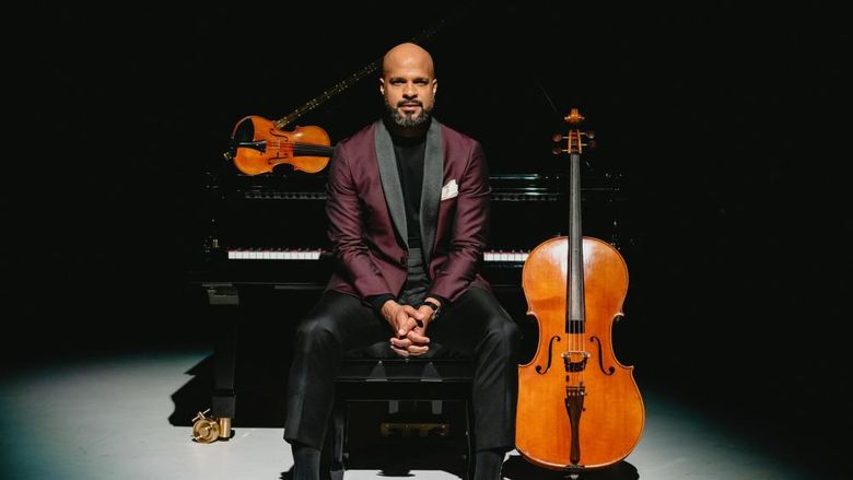 Barron Ryan, sitting at a piano, with a cello and violin