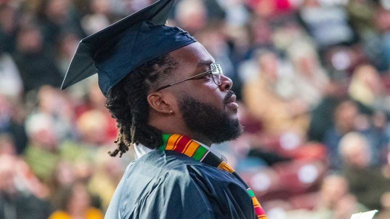 Profile of a graduate in cap and gown during fall 2024 commencement