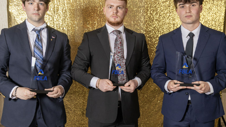 Three students hold FBLA trophies