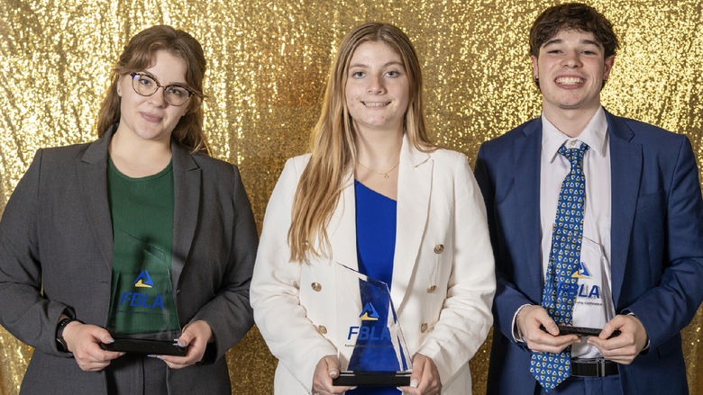 Three students hold FBLA trophies