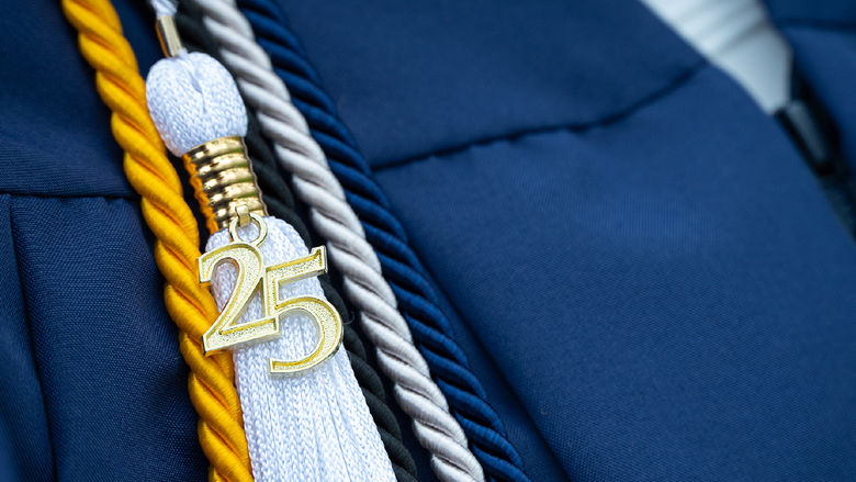 Closeup of a graduation tassel with a gold 25 attached