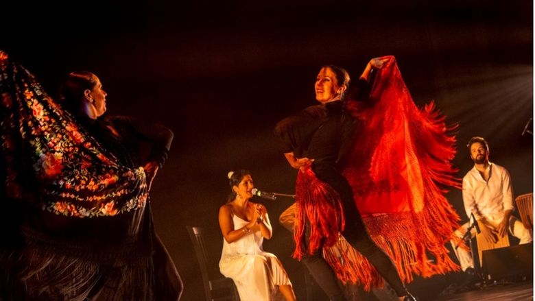 Two women dancing flamenco on stage.