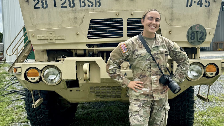 Jessica Barb stands in front of a military vehicle