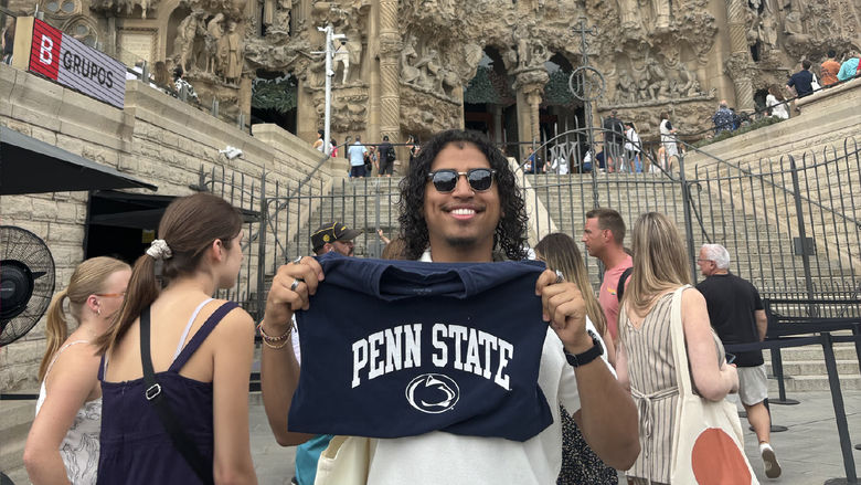Juan Serrano holds a Penn State t-shirt in front of the Sagrada Familia in Spain