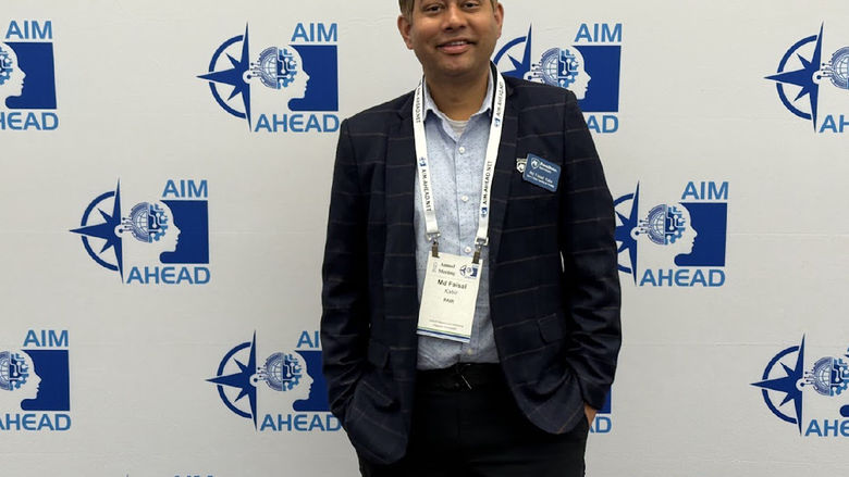 Md Faisal Kabir stands in front of an AIM AHEAD backdrop