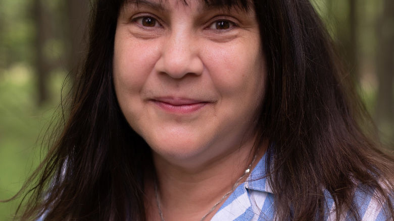 photo portrait of woman in woods wearing striped blouse