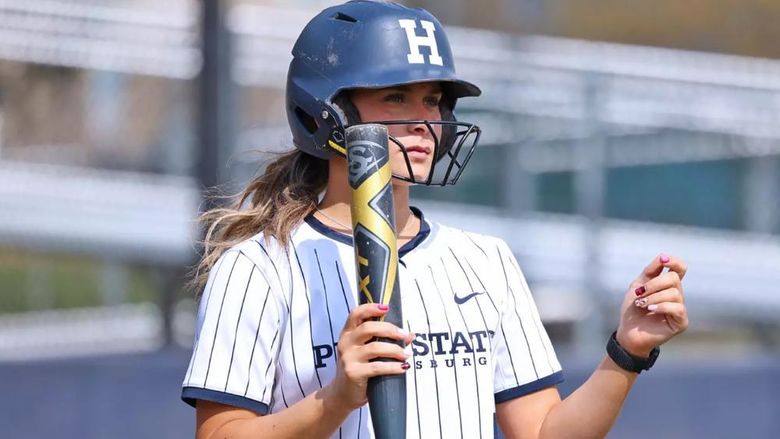 Madelyn Lehigh in a softball uniform holding a bat