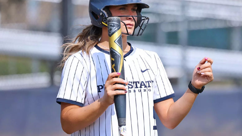 Madelyn Lehigh in a softball uniform holding a bat