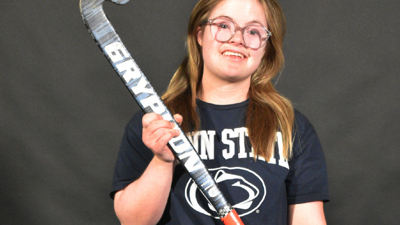 Maggie Kutz poses holding a field hockey stick
