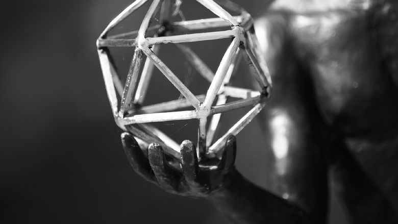 black and white image of sculpture hand and geometric figure
