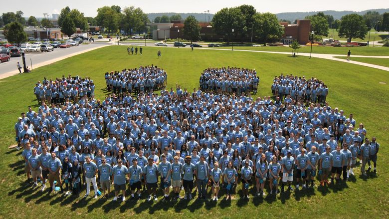Students forming the Nittany Lion Paw