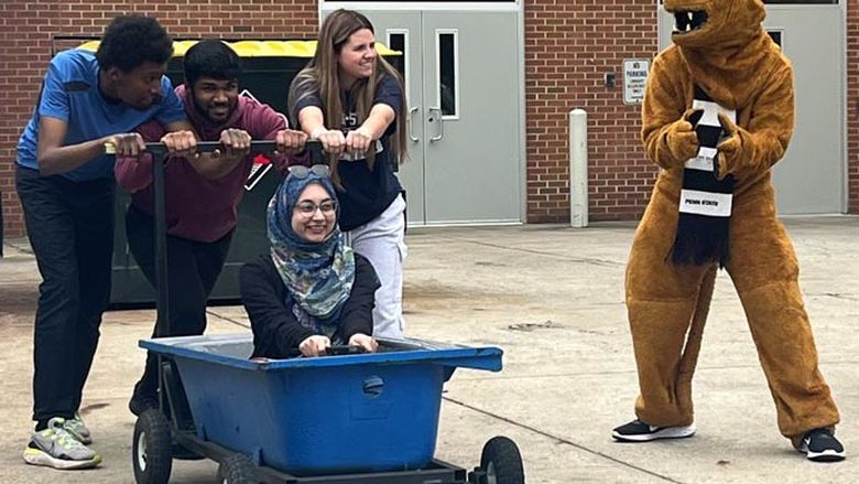 The Nittany Lion cheers the Career Studies team as they prepare to run the campus' annual Bathtub Race.