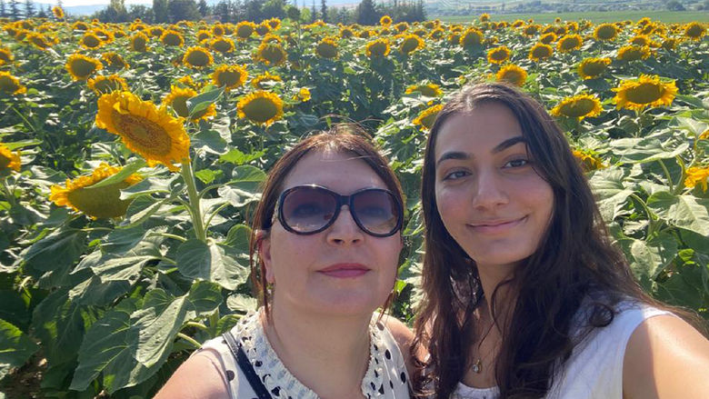 Senel Poyrazli and Dilan Kucukaydin in field of sunflowers.