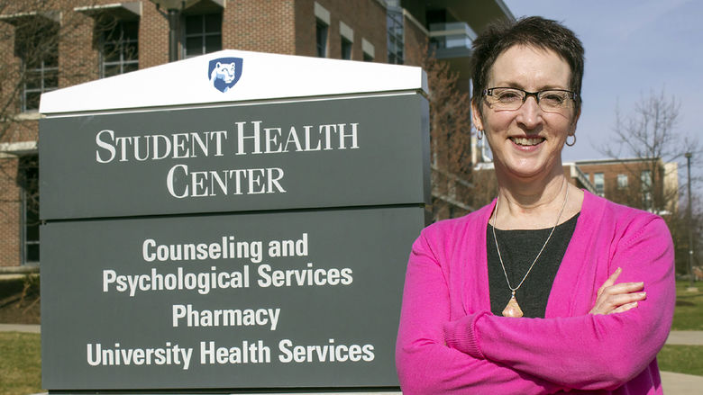 Shelley Haffner stands in front of a sign that reads "Student Health Center" in 2015