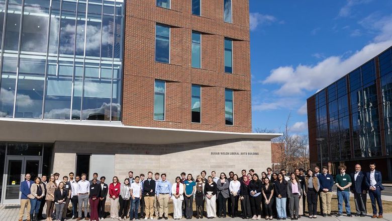 SPP simulation participants and judges pose in front of the Susan Welch Liberal Arts Building