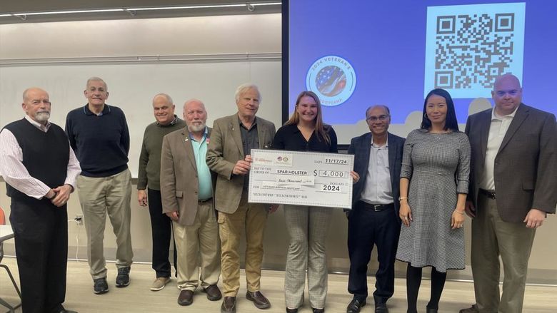 Erin Godfrey, winner of the Harrisburg LaunchBox Veterans Pitch Competition, holds a large check, surrounded by judges and others