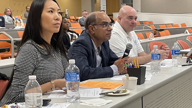 Three judges sit behind a table, listening to business pitches