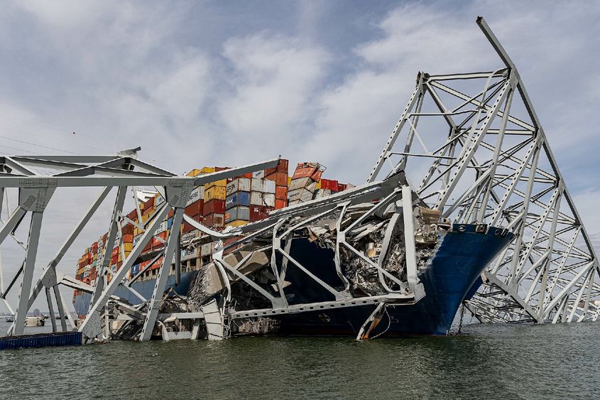 Cargo ship under bridge wreckage