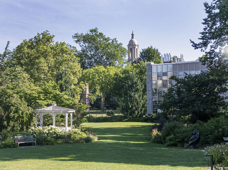 Hintz Family Alumni Center lawn on a sunny day with the Old Main bell tower in the background