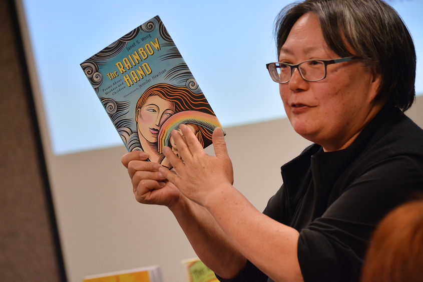 JAnet Wong holding up her book