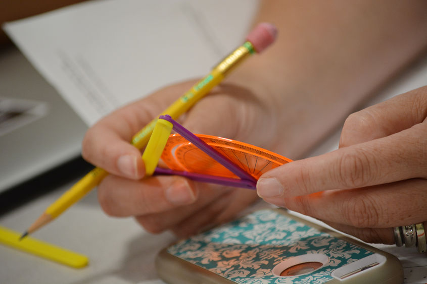 student hands with pencil and protractor