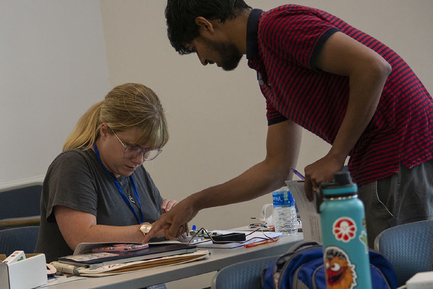 A teacher looks at Raspberry Pi computer parts while learning about coding