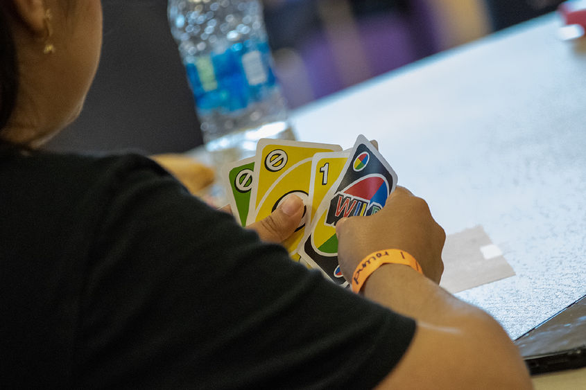 Closeup photo of hands holding Uno cards